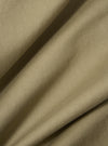 Close-up of the sand twill military chino fabric. The material is folded, showing the texture and color of the twill. The background is a plain surface.