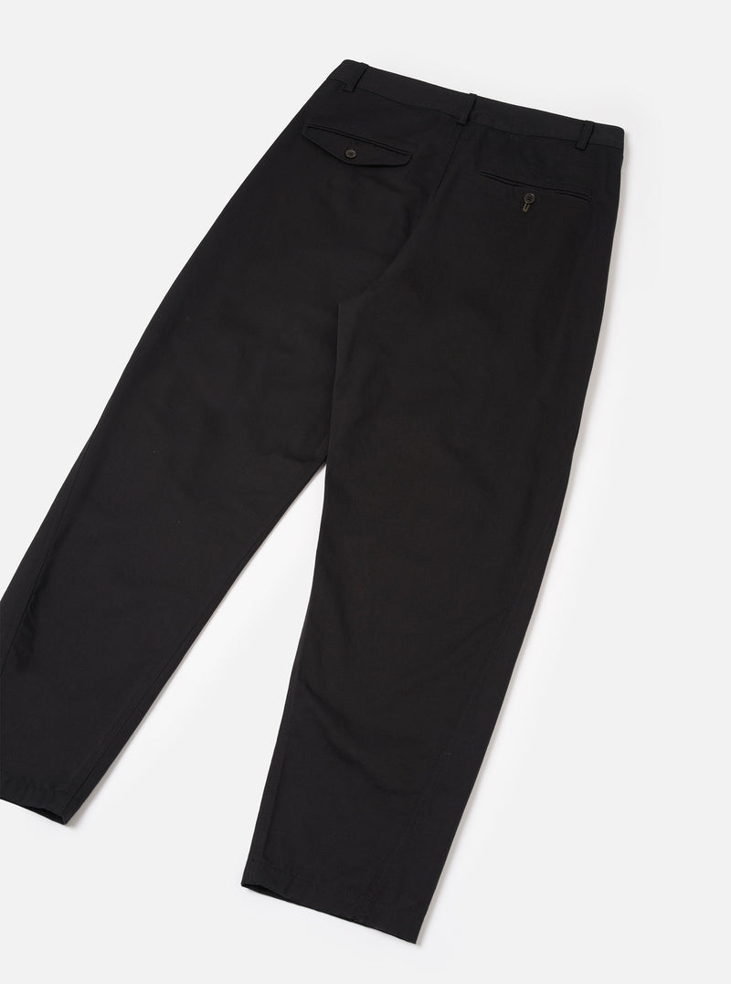 Rear view of the Black Twill Curved Pant against a clean white backdrop. Displays the relaxed curved leg cut, rear pockets including one jetted and one flap button pocket, and the heavy black cotton twill fabric construction.