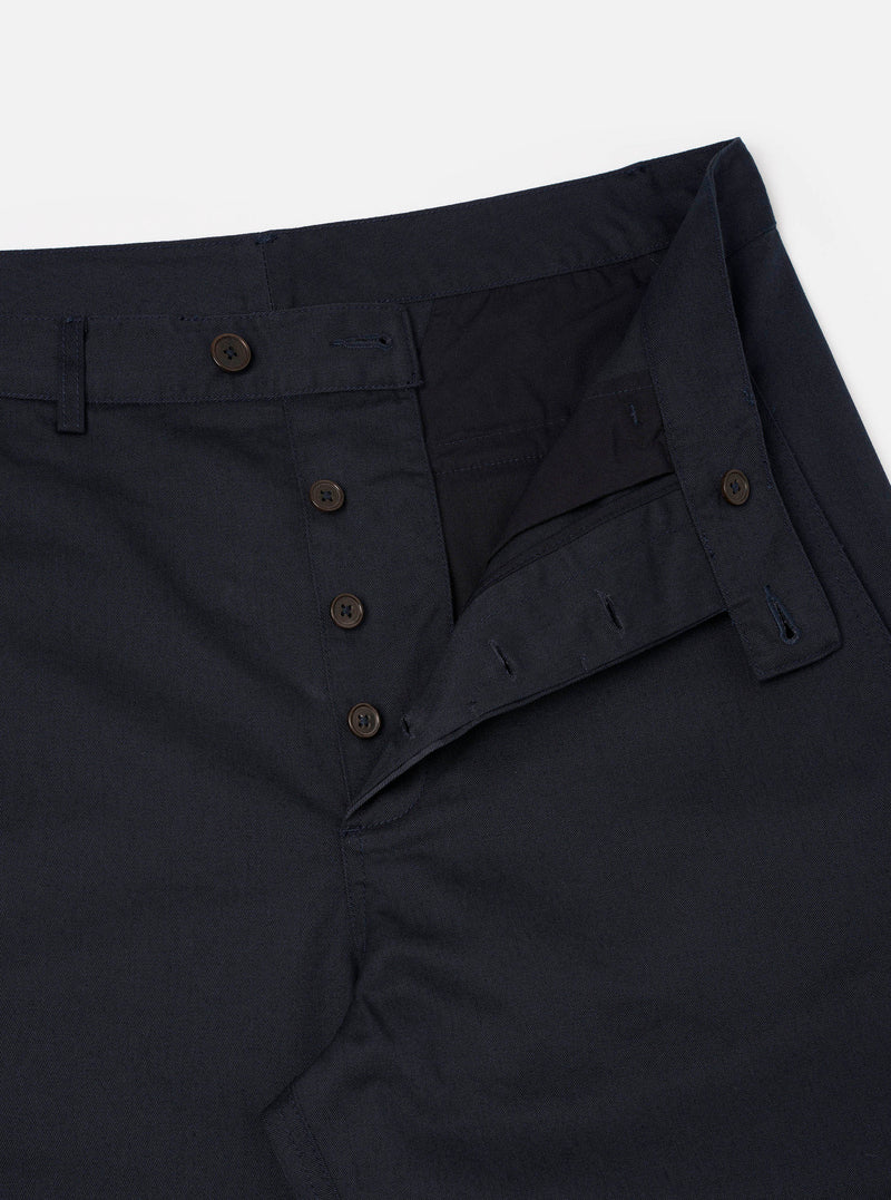 Close-up view of the Navy Twill Curved Pant shown on a neutral backdrop. Emphasizes the rich dark navy cotton twill weave, durable pocket stitching, waistband finish, and signature curved leg tailoring.