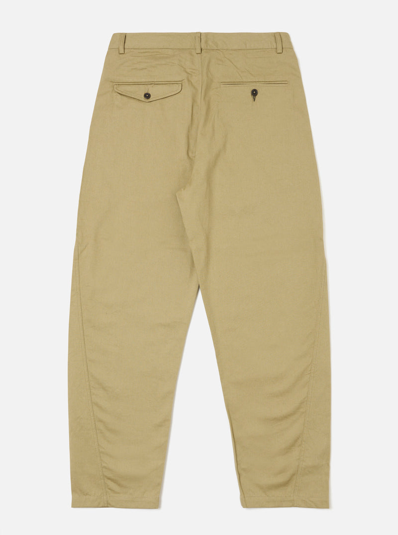 The Sand Twill Curved Pant in sand color, made of twill fabric, is laid out on a white background. The pants have a curved fit and visible back pockets.
