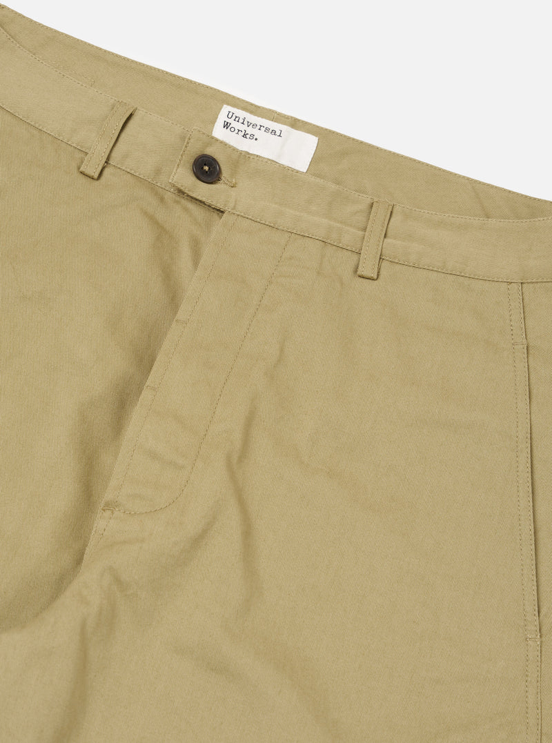 Close-up of the Sand Twill Curved Pant, showcasing the sand-colored twill fabric, curved design, button closure, and brand tag on a clean, white background.