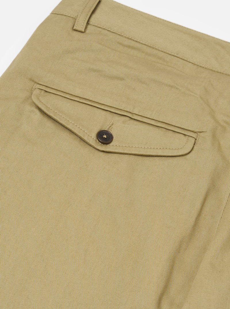 Close-up of the Sand Twill Curved Pant, showcasing the twill texture and back pocket detail with button closure. Shot on a white surface.