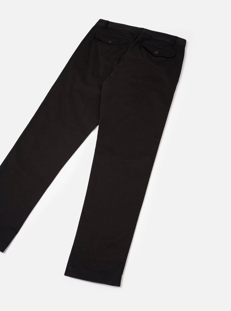 Rear view of the Black Twill Aston Pant displayed on a bright off-white backdrop. Features two rear buttoned flap pockets, structured waistband design, straight leg seams, and deep black twill material.