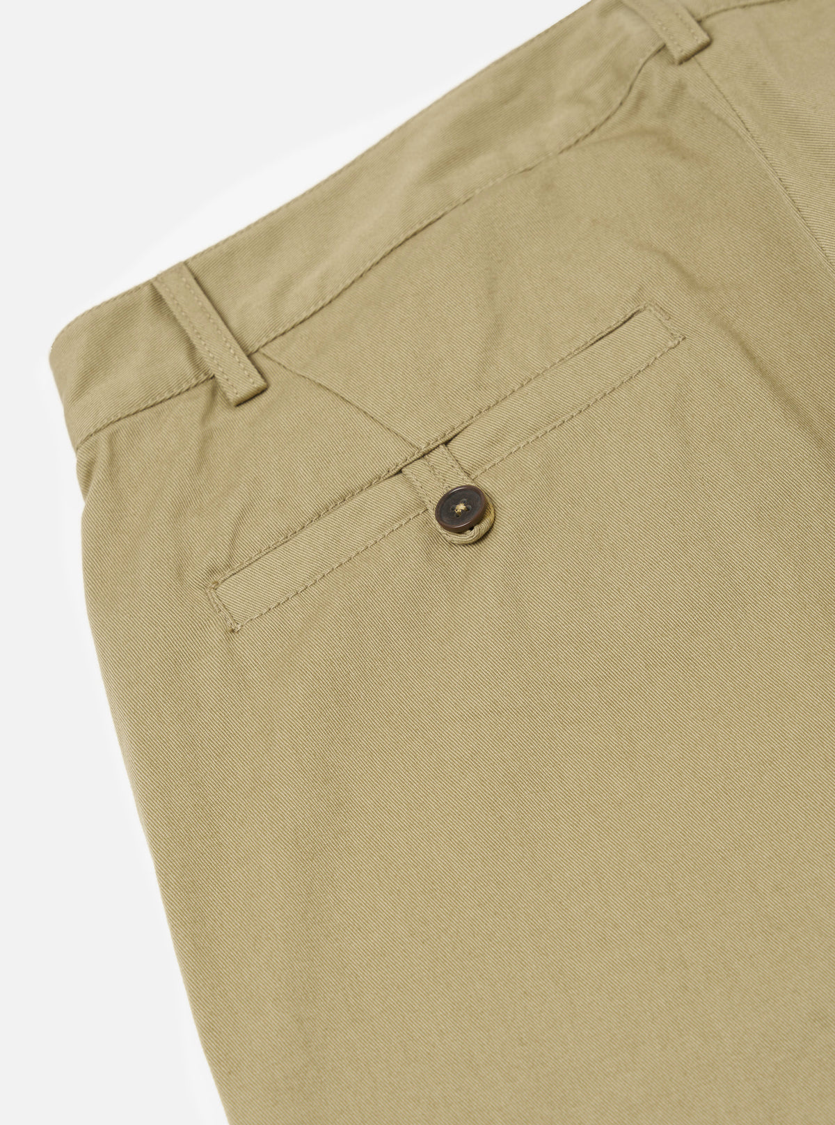 Close-up of the sand twill Aston Pant on a white background, showing the back pocket with button detail and belt loops.