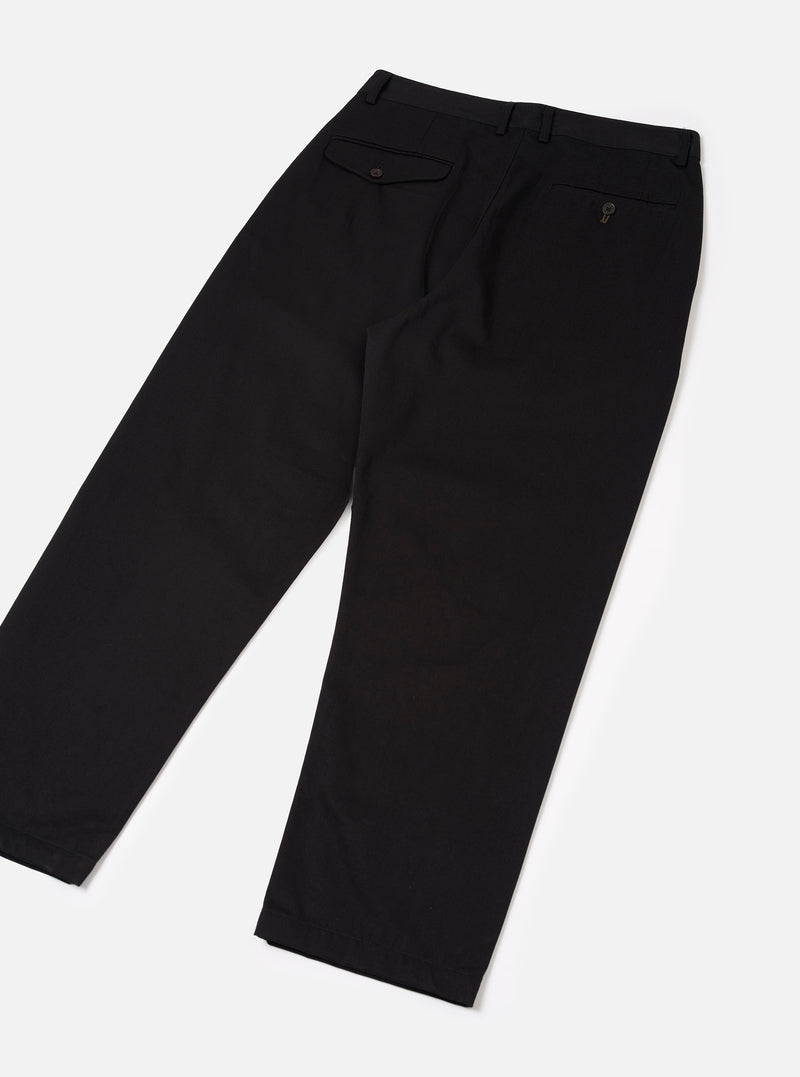Back view of the Black Twill Double Pleat Pant shown on a simple plain background. Displays the back welt pockets, clean tailored rear seams, wide leg opening, and dark black cotton twill fabric construction.