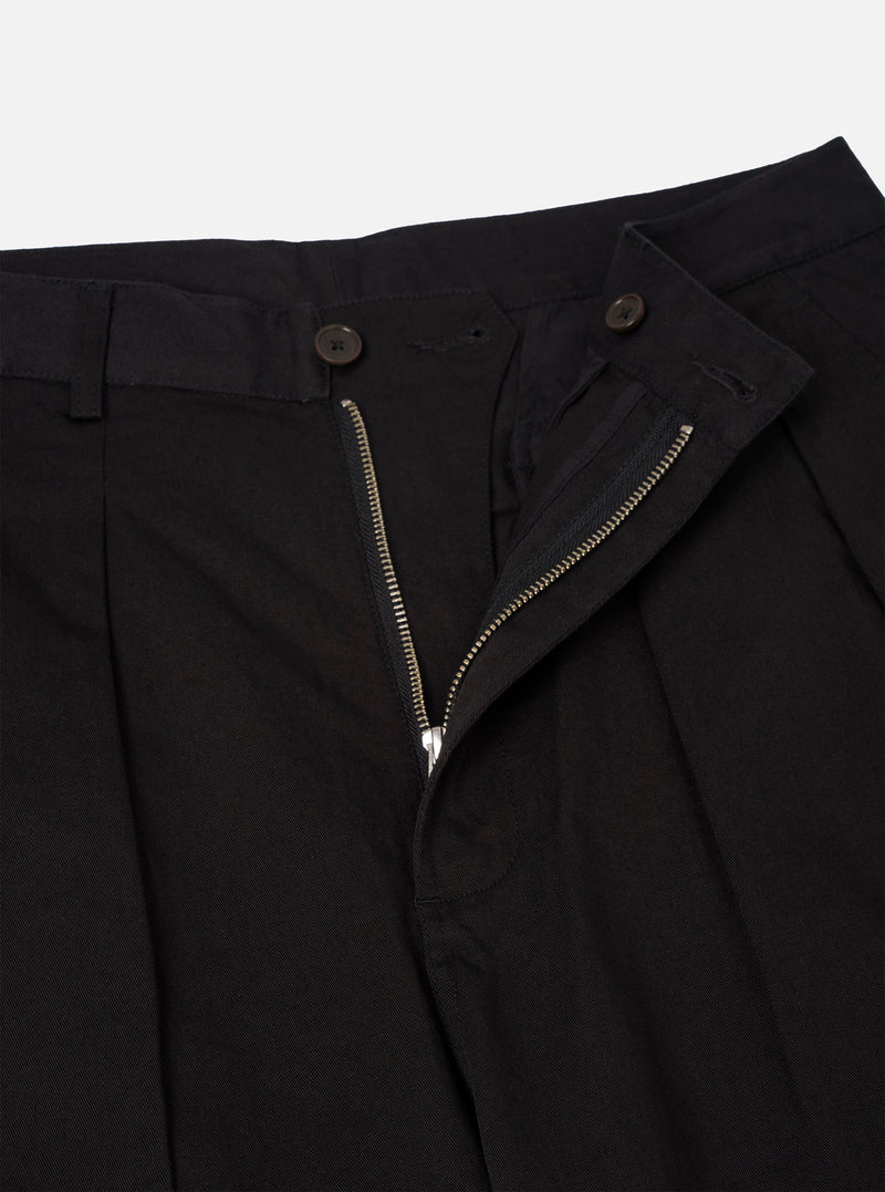 Detailed close-up view of the Black Twill Double Pleat Pant against a plain background. Focuses on the crisp front double pleats, sturdy belt loops, smooth button closure, and fine twill fabric weave.