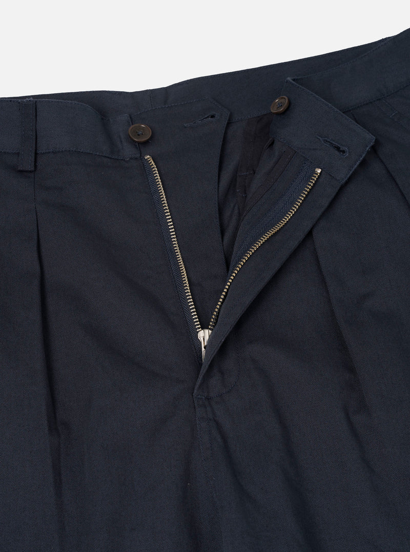 A close-up view of the Navy Twill Double Pleat Pant against a plain backdrop. Emphasizes the deep front pleat folds, waistband button closure, belt loop construction, and fine diagonal twill weave.