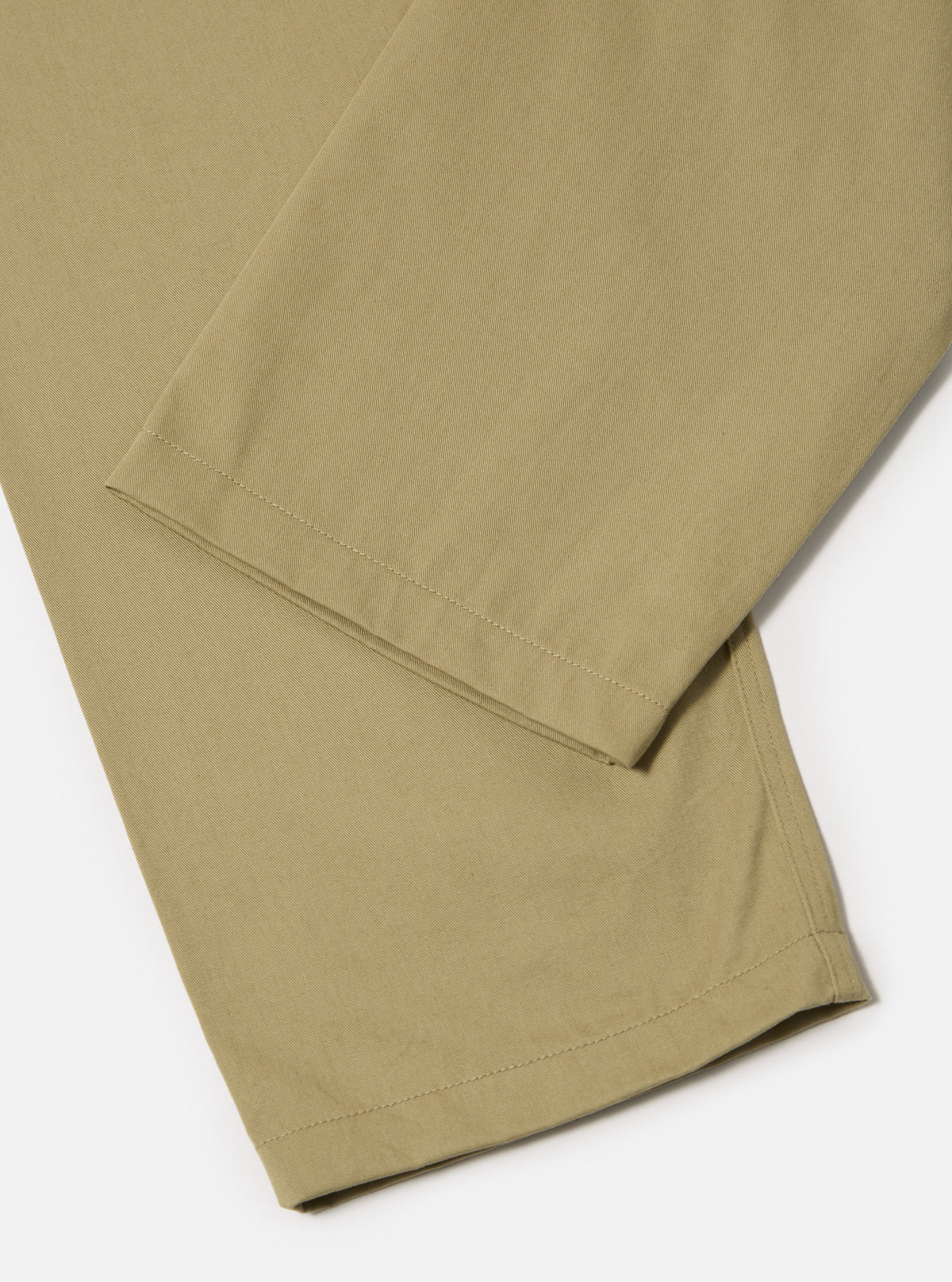 Close-up of the sand twill double pleat pant on a white background. The twill fabric is visible, showcasing the texture and construction of the pant.