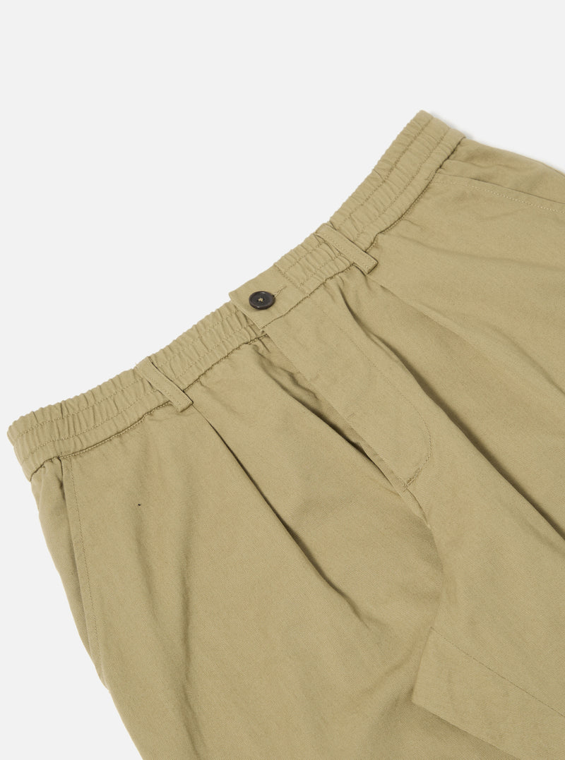 Close-up of the Sand Twill Pleated Track Pant on a white background. The sand-colored twill fabric shows pleats and an elastic waistband with a button closure.