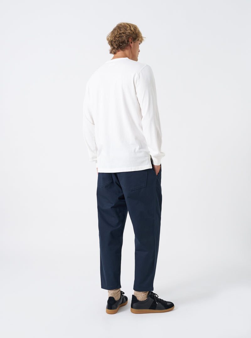 Rear shot of a model wearing the Navy Twill Hi Water Trouser against a plain white background. Shows the rear patch pockets, comfortable gathered waistband, straight loose thigh, and cropped hem length above the shoes.