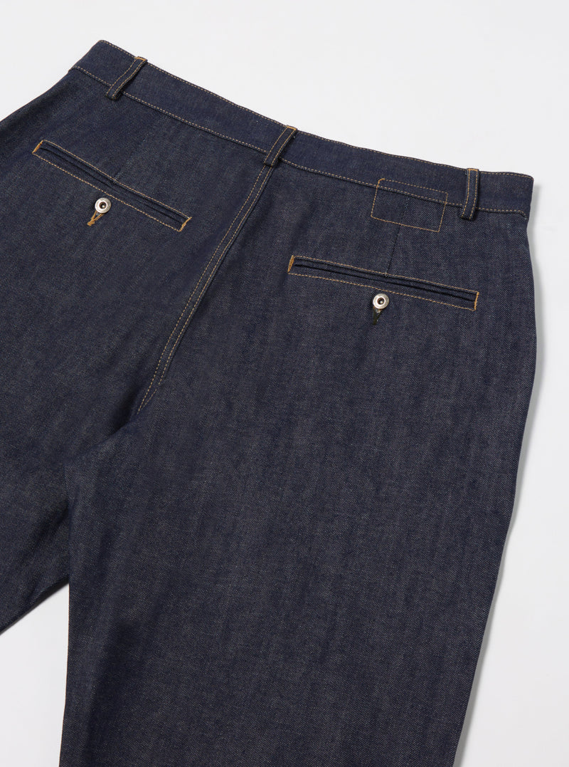 A detailed view showing the turn-up hem of the Indigo 13oz Selvedge Denim Military Chino against a white backdrop. Features the prominent red selvedge ID edge along the inner side seam and the dark indigo twill denim fabric.