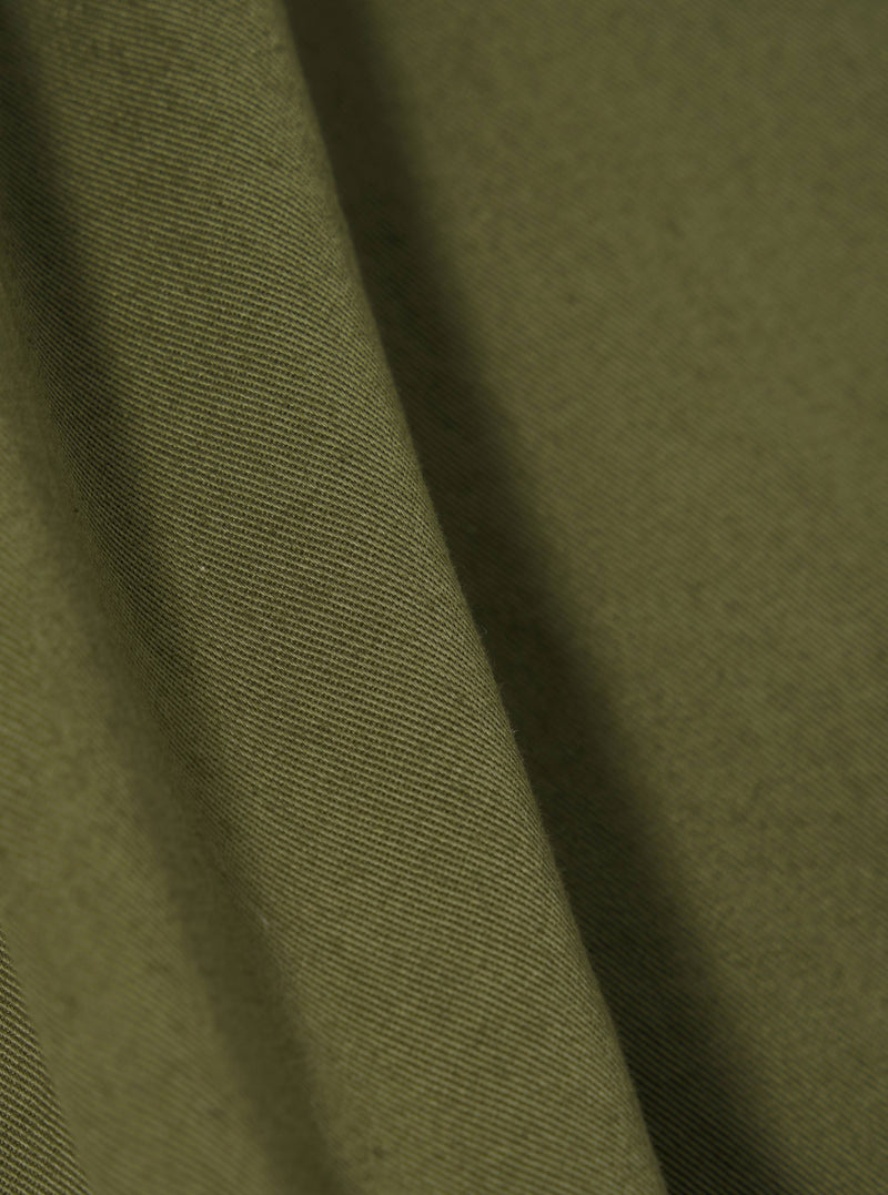 A close-up swatch image of the Light Olive Twill Beach Short fabric. The image focuses on the light olive green cotton twill material, highlighting its diagonal weave texture and consistent color. The background is a plain white.