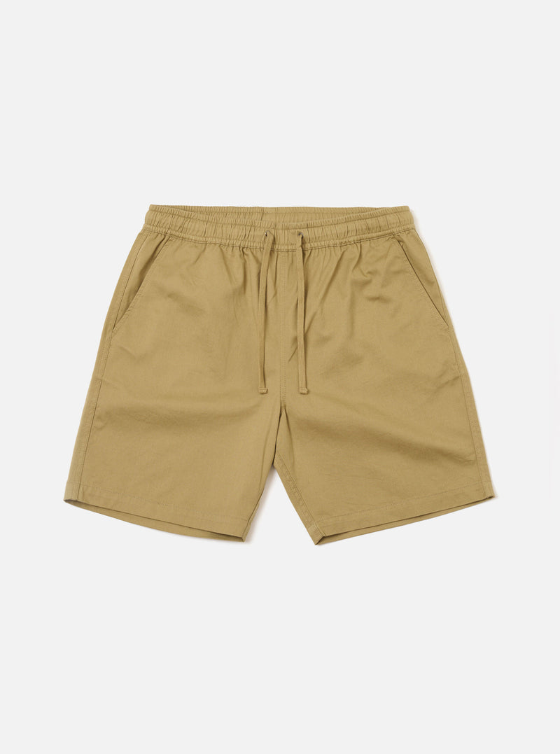 The Sand Twill Beach Short is presented as a flat lay against a solid white background. These light beige shorts feature an elasticated waistband with an internal drawstring and two large patch pockets on the front. The cotton twill fabric has a visible diagonal weave.