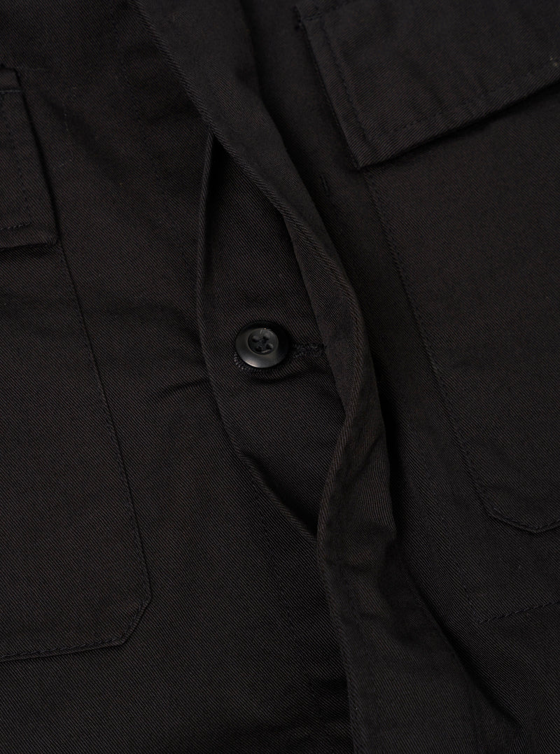 A close-up view of the Black Twill MW Fatigue Jacket on a plain white background. The image details the fine texture of the black cotton twill, durable stitching, spread collar, and upper flap chest pocket structure.