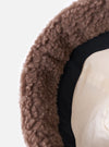 Close-up of the inside of a cableami® Brown Toque Boa Cap. The hat has a brown, boa-like exterior, a black band, and a cream-colored lining. Shot on a white background.