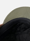 Close-up of the inside of a cableami® Olive Military Nylon Twill Cap, showing the quilted black lining and olive nylon exterior on a white background.