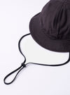 The cableami Black Baker Back Satin Cotton Metro Hat is shown from a rear angle as a flat lay against a plain white background. The image highlights the rounded crown construction with visible vertical seams and the downward-sloping brim. The black cotton fabric has a subtle, durable back-satin texture.