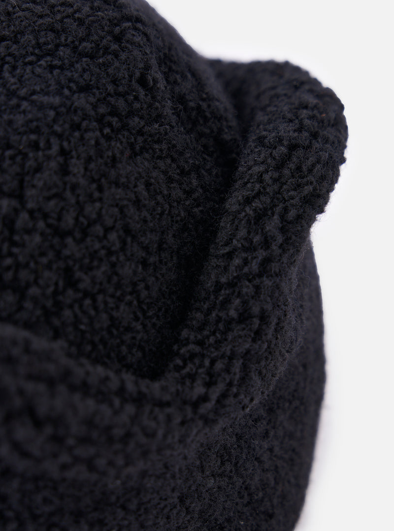 Close-up of the cableami® Black Recycled Wool Flight Watch Cap, showing the texture of the wool. The cap is on a white background.