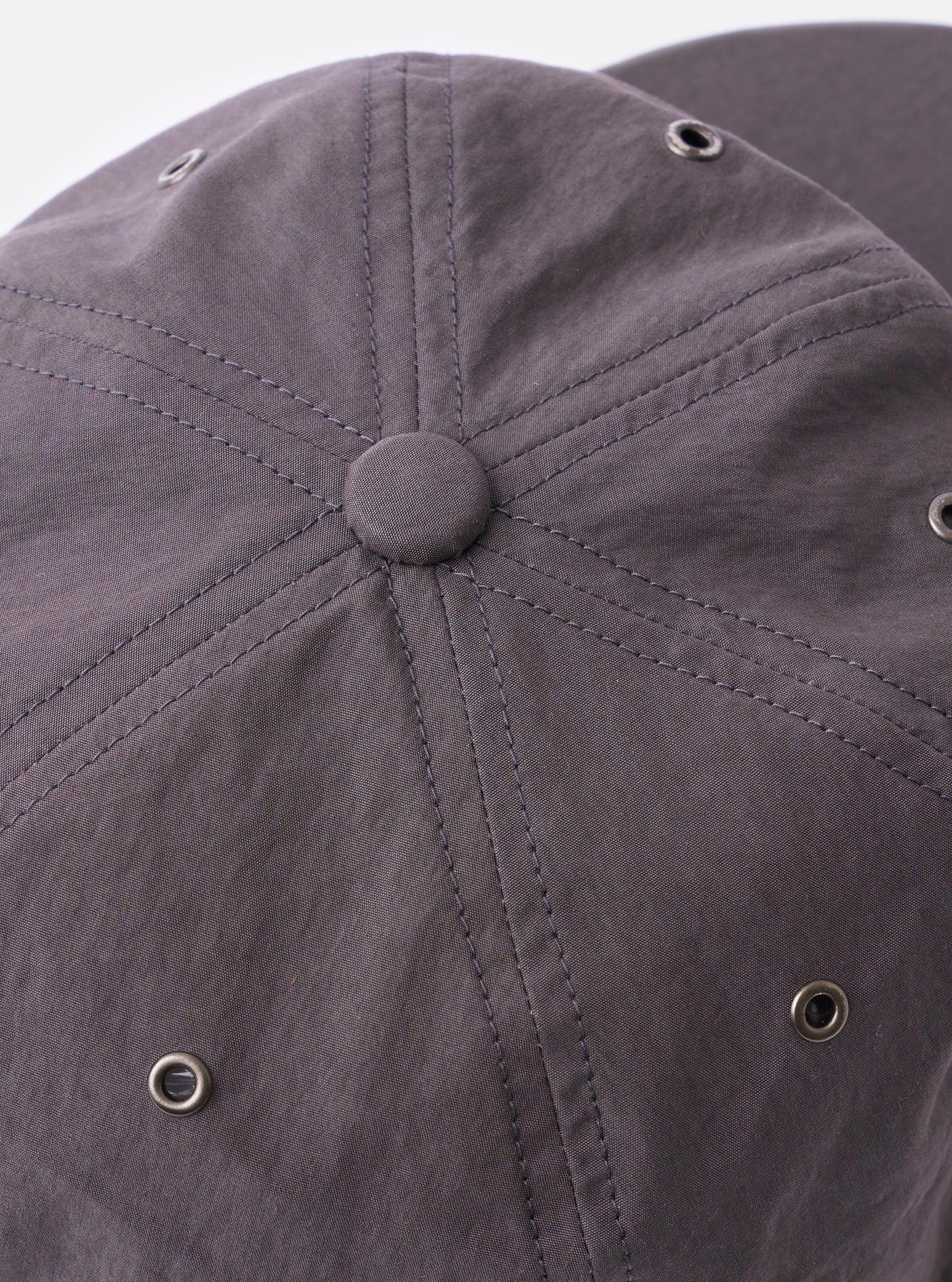The cableami Grey/Olive Cotton/Nylon B.B Cap is shown in a side-profile view as a flat lay against a plain white background. The image highlights the six-panel construction, the curved brim in a contrasting olive green, and the grey crown. An adjustable leather strap with a metal buckle is visible at the back.