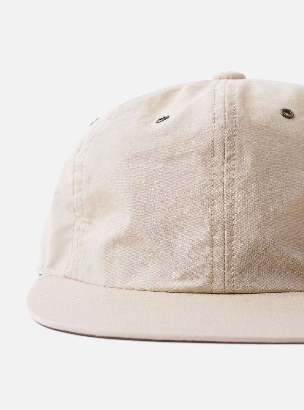 The cableami Ivory/Olive Cotton/Nylon B.B Cap is shown from a side angle as a flat lay against a plain white background. The cap features a two-tone design with an ivory crown and a contrasting olive green curved brim. The construction includes a structured six-panel crown with tonal eyelets and a top button.