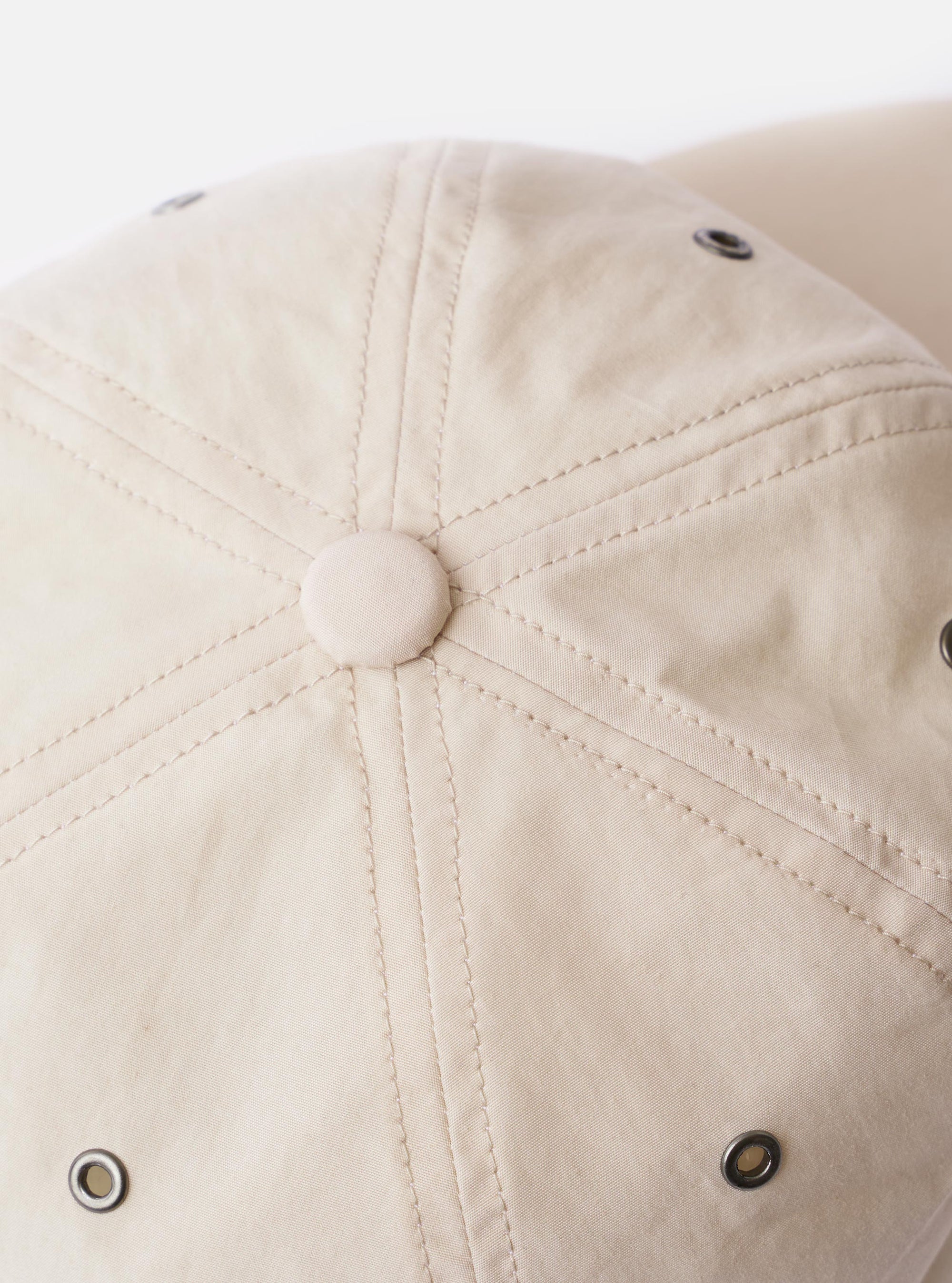 The cableami® Ivory/Olive Cotton/Nylon B.B Cap is shown from the back as a flat lay against a plain white background. The image highlights the rear of the six-panel crown and the elasticated band designed for a flexible fit. The cap features an ivory body with a contrasting olive brim and top button.