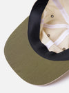 The cableami Ivory/Olive Cotton/Nylon B.B Cap is shown in a detail view from the back as a flat lay against a plain white background. The image highlights the adjustable olive green fabric strap with a metal buckle and the ventilation eyelets on the ivory crown.