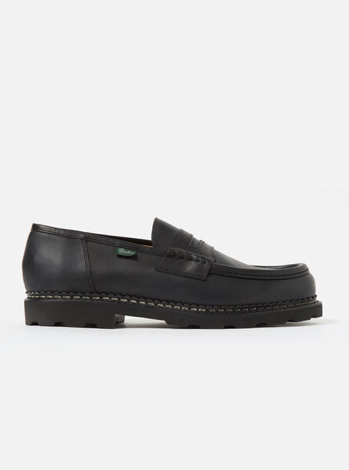Studio shot of a Paraboot Black Leather Reims Marche shoe. The black leather loafer has a thick sole. Clean white background.