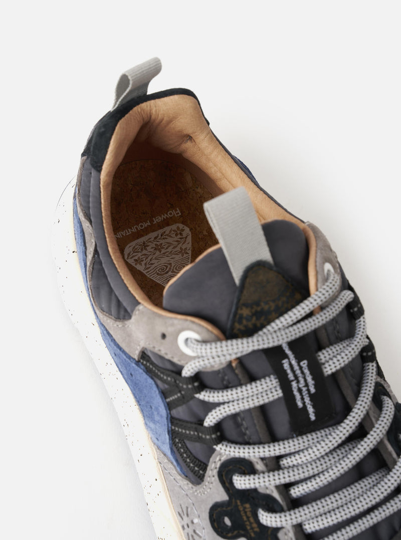 Close-up detail view of the Flower Mountain Dark Grey/Grey/Navy Suede/Nylon Yamano 3 Man sneaker on a plain white backdrop. Highlights the rich dark grey suede texture, contrast stitching, nylon paneling, and rugged trail-inspired lug sole.
