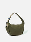 The master-piece x Universal Works Olive Medium Canvas Shoulder Bag is shown from the back as a flat lay against a plain white background. The image highlights the olive green canvas fabric, a large rear slip pocket, and the attachment points for the adjustable webbed shoulder strap.
