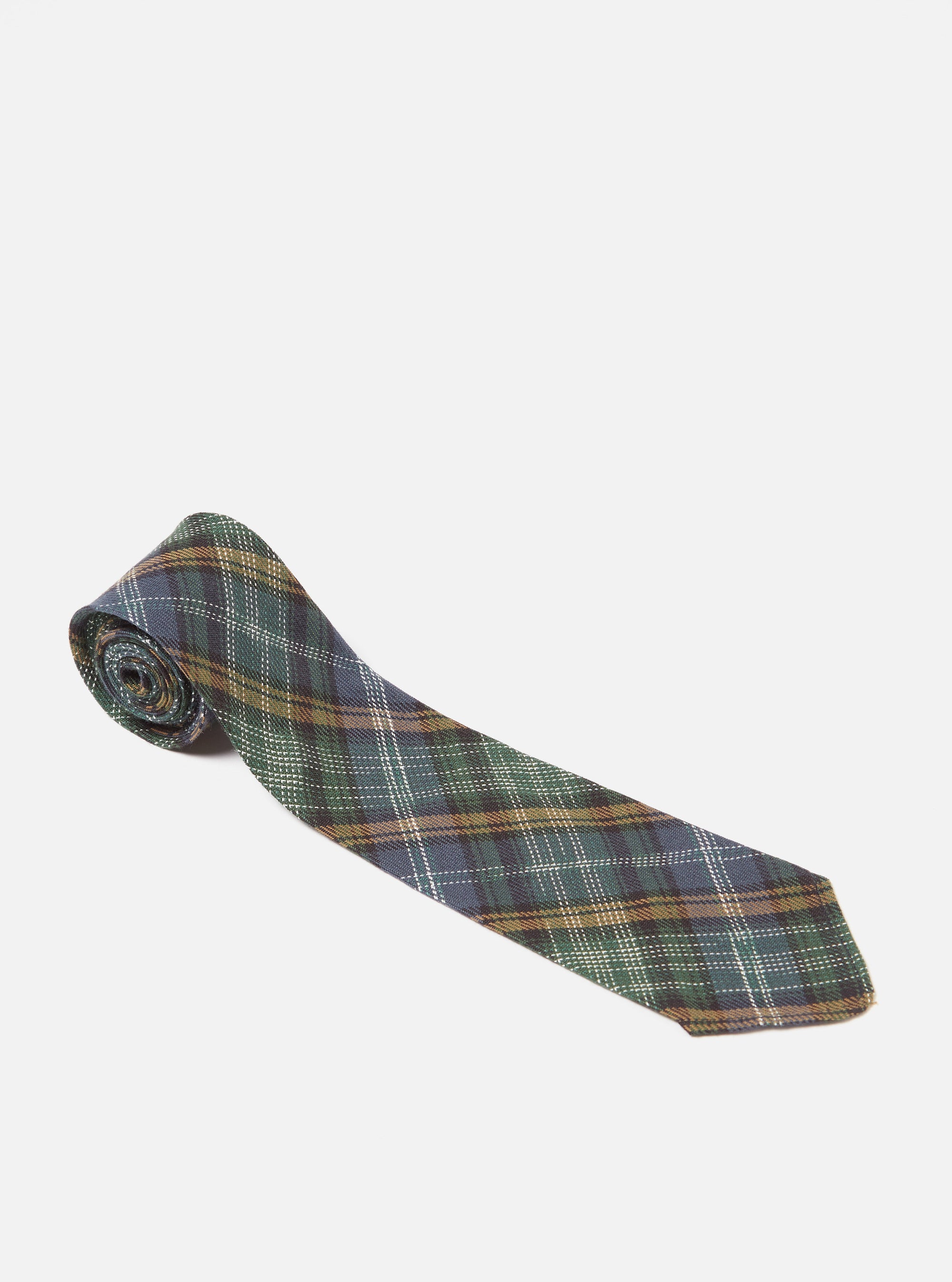 The Green Ikat Twill Check Tie is displayed on a white background. The tie features a green, blue, and brown plaid pattern.