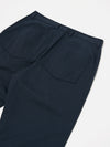 Close-up of the back of the Navy Twill Duke Pant on a white surface. The pants are a dark navy color and made of twill fabric. They have a relaxed fit with back pockets.