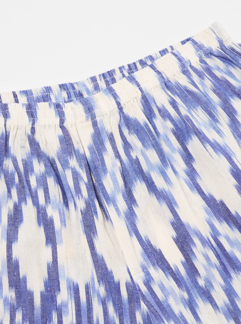 Close-up of the Ecru Ikat I Cotton Boxer Short. The cotton fabric features a blue ikat pattern on an ecru background. The shorts have an elastic waistband. Shot on white.