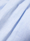 Close-up of the Ice Blue Recycled Cotton Pyjama Short fabric. The light blue cotton is textured and folded on a white surface.