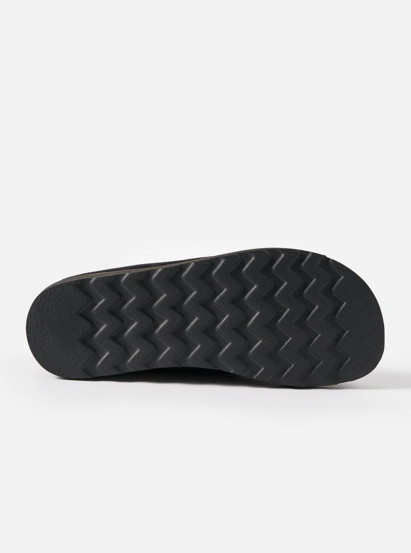 Close-up of the sole of the Zardus for Universal Works Black Suede Oliver sandal. The black rubber sole has a zig-zag pattern. Shot on a white background.