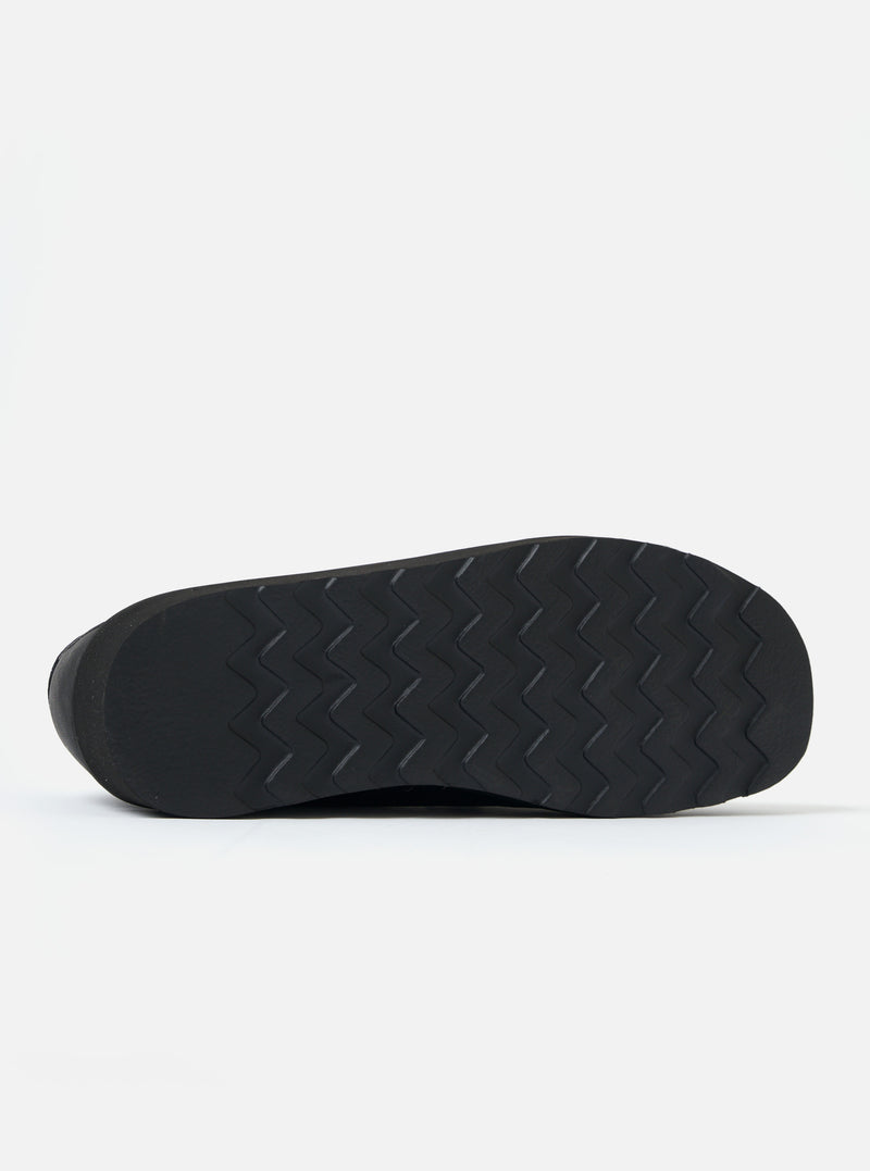 Close-up of the sole of the Zardus for Universal Works Black Leather Reggie Loafer, showing the textured black rubber against a white background.
