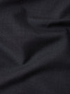Close-up of the Charcoal Tropical Suiting Oxford Pant fabric. The dark charcoal material is softly draped, showcasing its texture and quality.