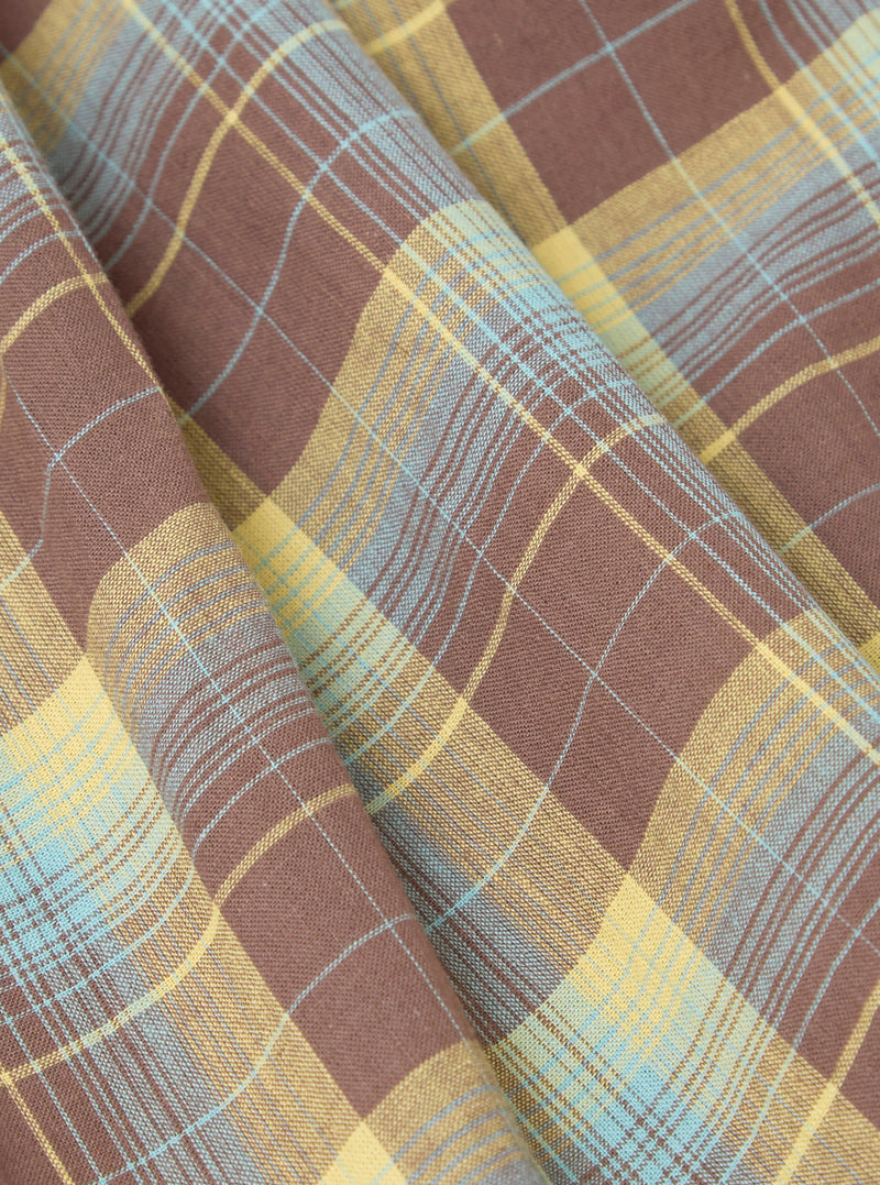 Close-up of Multi Check 3 Pack Boxer Short fabric. Brown, yellow, and blue plaid pattern. Soft cotton material, folded on a flat surface.