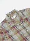 Close-up of the Green Kip Check Long Pyjama Set top. The shirt, in a green, red, and blue plaid, is on a white background. The Universal Works label is visible.