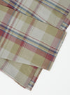 Close-up of the Green Kip Check Long Pyjama Set fabric. The soft, brushed cotton has a green, red and blue check pattern. Shot on a white background.