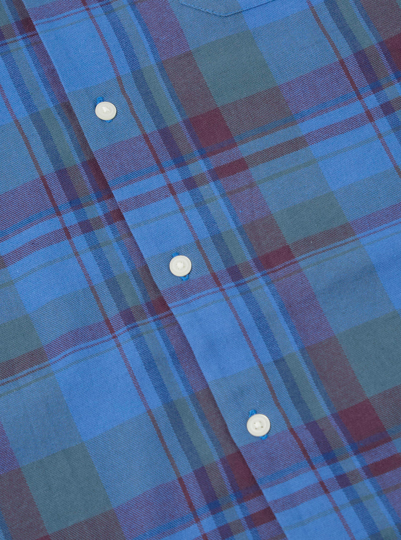 Close-up of the Blue Kip Check Long Pyjama Set. Features a blue, green, and maroon plaid pattern with white buttons. The fabric is soft and comfortable.