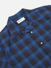 Close-up of the Navy/Blue Check Short Pyjama Set shirt. The fabric is a blue and navy check pattern. The shirt has a camp collar and white buttons. Shot against a white backdrop.