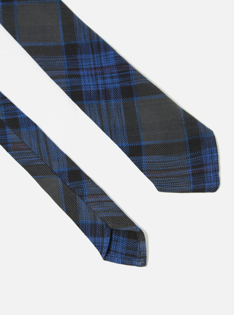 Close-up of a Navy Ikat Twill Check Tie on a white background. The tie features a blue and black check pattern.