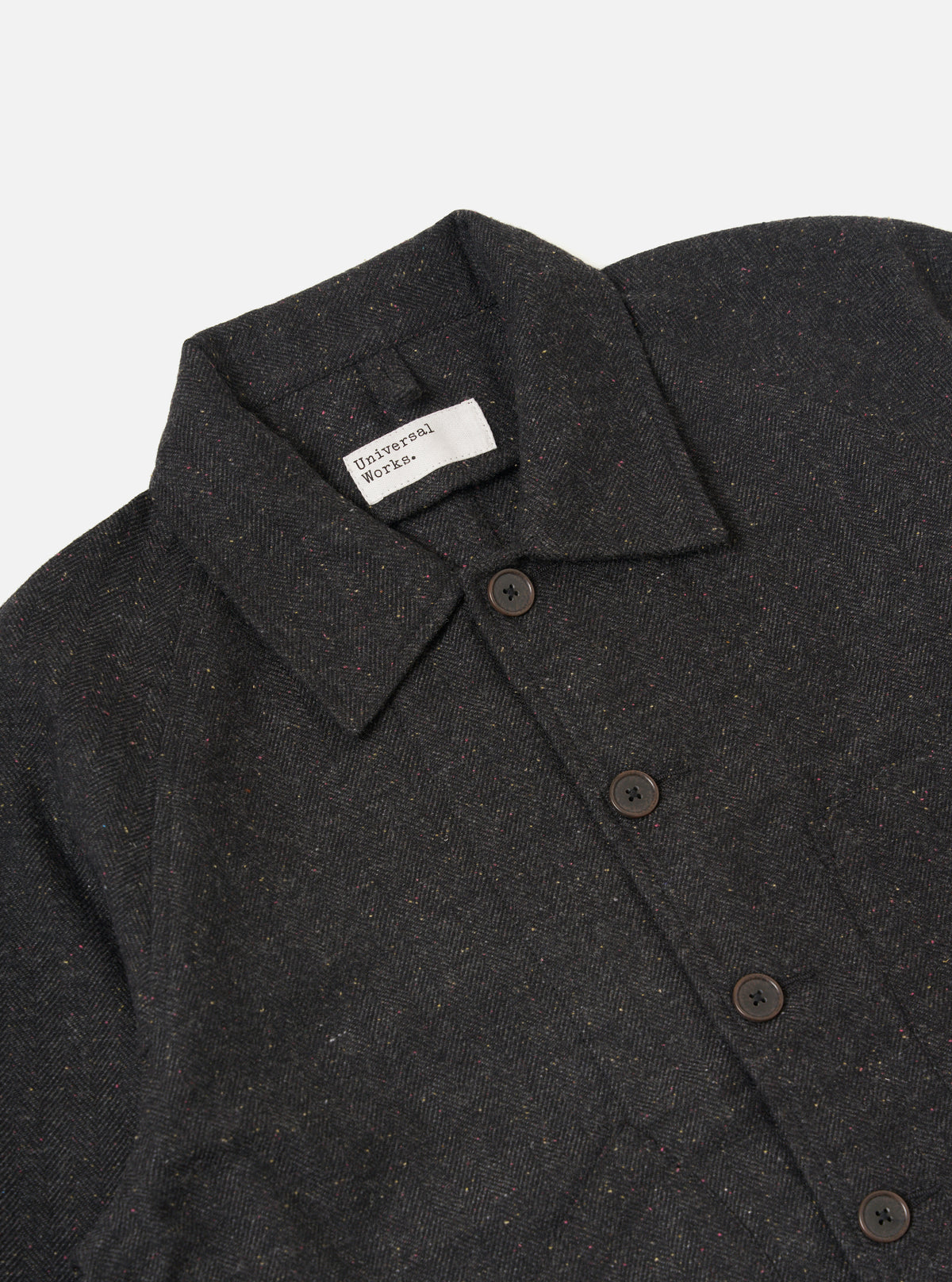 Close-up of the Black Salt N Pepper Tweed Station Jacket on a plain white background. The tweed material is visible, along with the button closure and brand label.