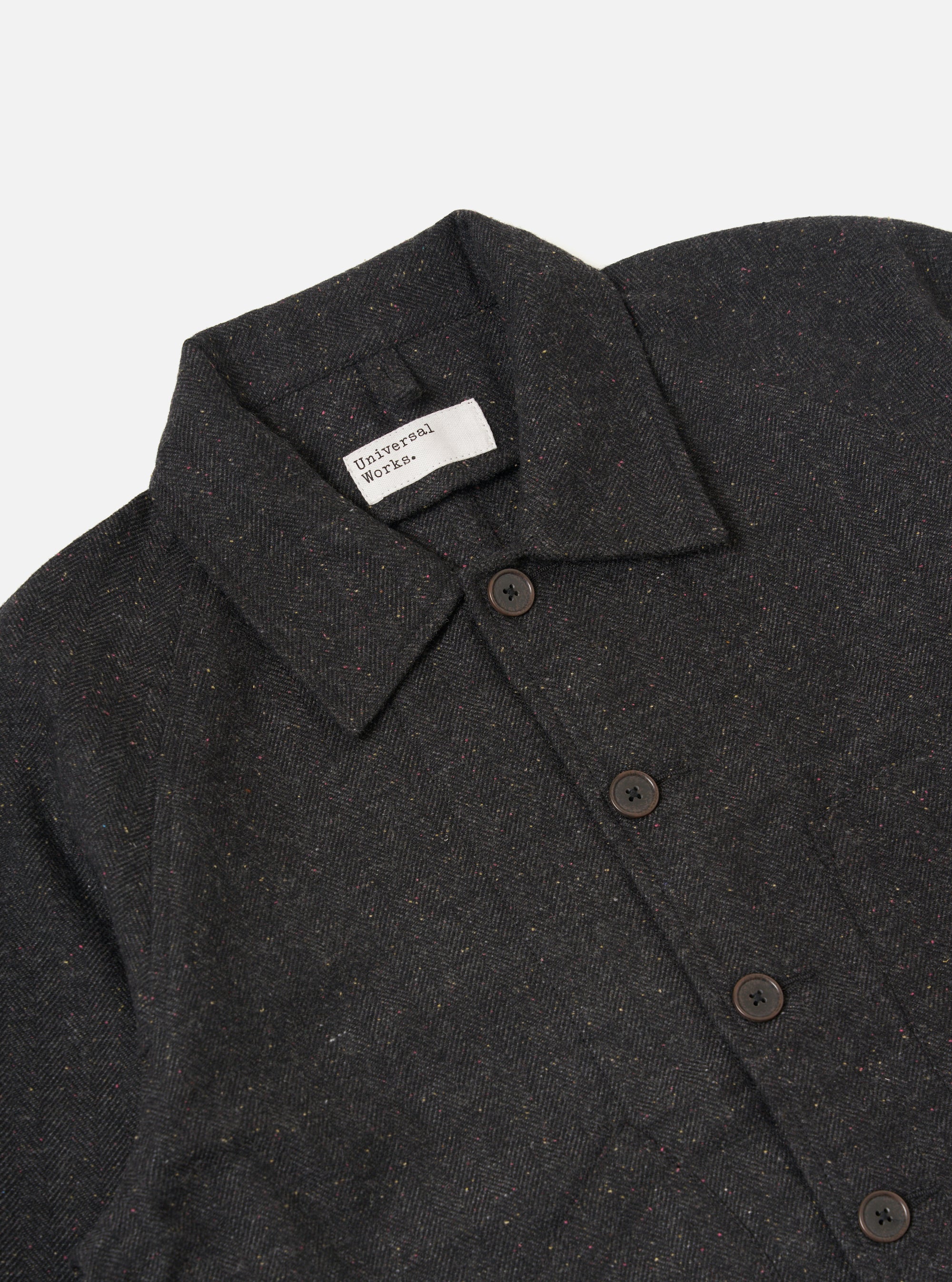 Close-up of the Black Salt N Pepper Tweed Station Jacket on a plain white background. The tweed material is visible, along with the button closure and brand label.