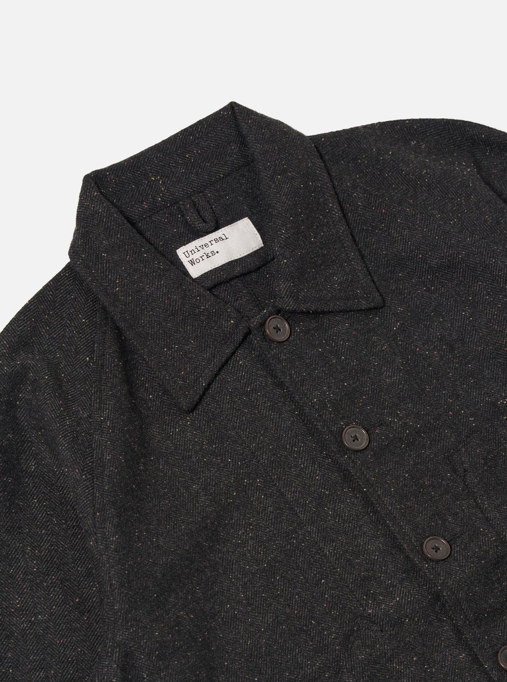 Close-up of the Black Salt N Pepper Tweed Station Jacket on a white background. The tweed is dark with flecks of color. The jacket has a collared neck and button closure.