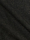 Close-up of the Black Salt N Pepper Tweed Three Button Jacket. The tweed fabric has a subtle herringbone pattern with flecks of yellow and pink. The background is a plain surface.