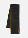 A black wool scarf with yellow trim is displayed on a white background. The Black Wool Scarf has the words 'Universal Works' embroidered on it.