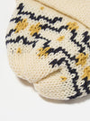 Close-up of the Ecru/Navy British Wool Short Watch Cap on a white surface. The cap features a knit pattern with ecru, navy, and gold colors.