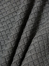 Close-up of the grey textured Merino knit Charlie Cardigan, showing the soft material and detailed knit pattern. The fabric is draped to highlight its texture.