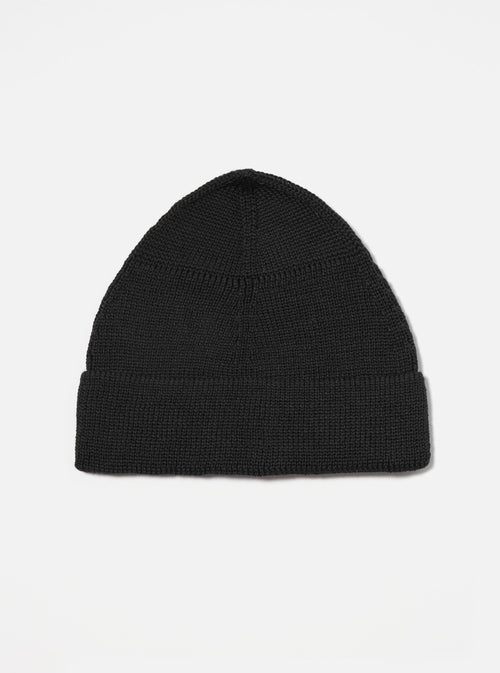 Close-up of a navy merino knit watch cap on a white background. The hat is neatly folded, showcasing its fine knit texture and classic fit. A simple, clean shot of the Navy Merino Knit Watch Cap.